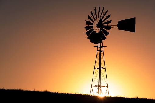Silhouette of a windmill during sunset on a sunny day