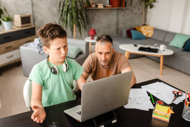 istock Confused school boy having hard time while doing homework but his father is there to help him 1223225313