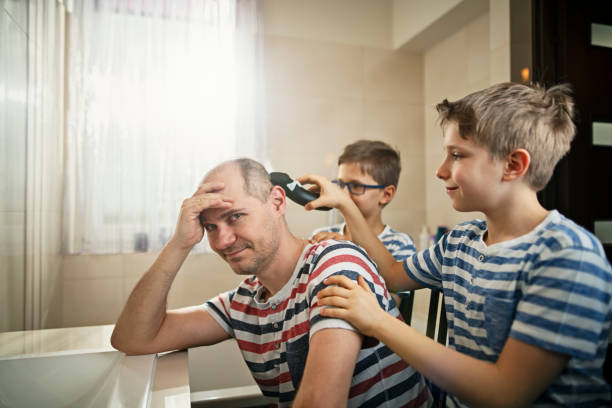 Little boys having fun cutting their father's hair Father and son having fun together. Sons are cutting the father's hair. The father is looking desperately at the camera.
Nikon D850 cutting hair photos stock pictures, royalty-free photos & images
