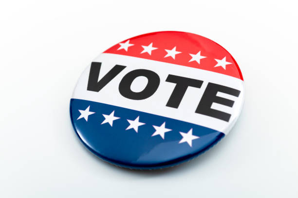 democracy, presidential election and voting poll concept with red, white and blue vote glossy button pin with stars and stripes isolated on white background with clipping path cutout - vote button imagens e fotografias de stock