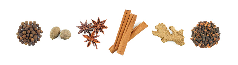 Top view of dry spices: allspice, nutmeg, star anise, cinnamon sticks, dried ginger and clove. Collection isolated on white background.