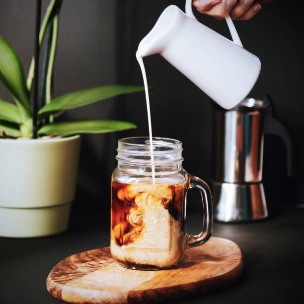 istock Mug of iced coffee into which milk is poured 1223236355