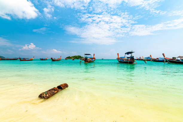 Long tail boats in small harbor at Ko Lipe island, south Thailand. Tropic and exotic island is symbol of tropical paradise, part of Tarutao national nature park. Vibrant colors, turquoise water. Long tail boats in small harbor at Ko Lipe island, south Thailand. Tropic and exotic island is symbol of tropical paradise, part of Tarutao national nature park. Vibrant colors, turquoise water. tarutao stock pictures, royalty-free photos & images