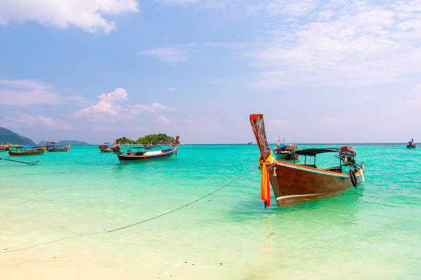 Long tail boats in small harbor at Ko Lipe island, south Thailand. Tropic and exotic island is symbol of tropical paradise, part of Tarutao national nature park. Vibrant colors, turquoise water. Long tail boats in small harbor at Ko Lipe island, south Thailand. Tropic and exotic island is symbol of tropical paradise, part of Tarutao national nature park. Vibrant colors, turquoise water. tarutao stock pictures, royalty-free photos & images