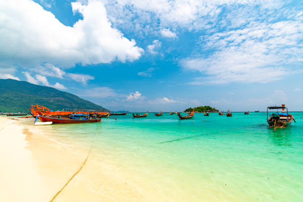 Long tail boats in small harbor at Ko Lipe island, south Thailand. Tropic and exotic island is symbol of tropical paradise, part of Tarutao national nature park. Vibrant colors, turquoise water. Long tail boats in small harbor at Ko Lipe island, south Thailand. Tropic and exotic island is symbol of tropical paradise, part of Tarutao national nature park. Vibrant colors, turquoise water. tarutao stock pictures, royalty-free photos & images