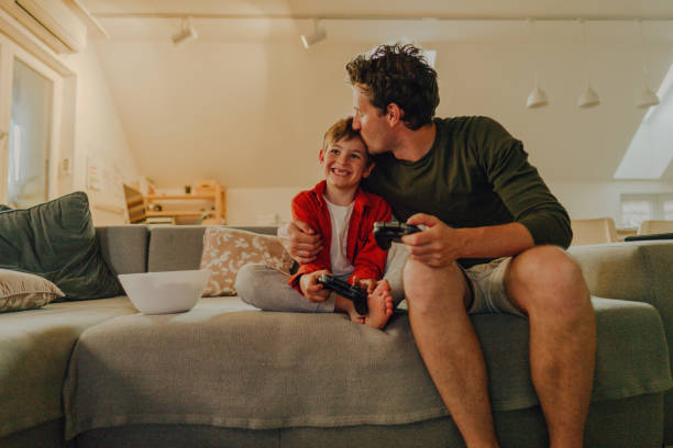 Father and son playing video games at home