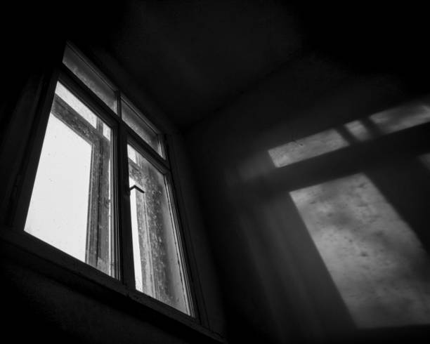 istock Monochrome isolated bottom view to vintage tiled window frame with shadow and light beam from outdoors in dark room 1223239142