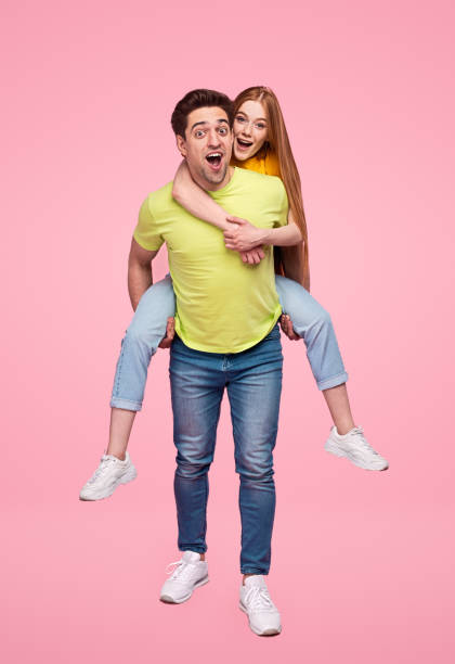 istock Cheerful man carrying girlfriend on back 1223240259