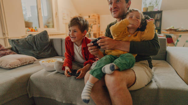 istock Father and sons playing video games at home 1223240504