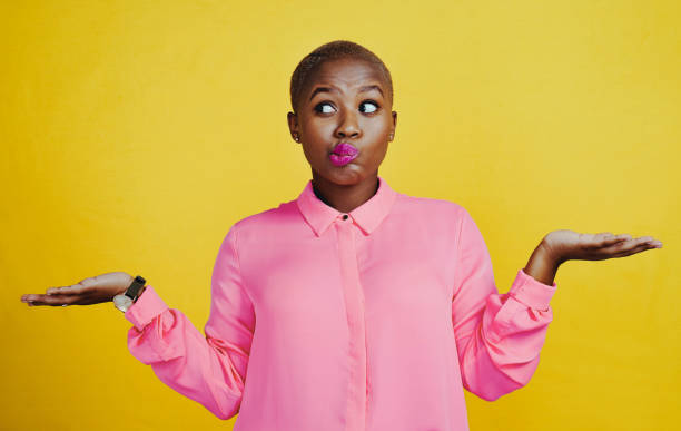 This is a tough decision to make Cropped shot of an attractive young woman looking curious and indecisive against a yellow background shaved black women stock pictures, royalty-free photos & images