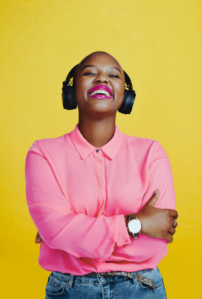 This song brings back so many happy memories Cropped shot of an attractive young woman listening to music on headphones against a yellow background shaved black women stock pictures, royalty-free photos & images
