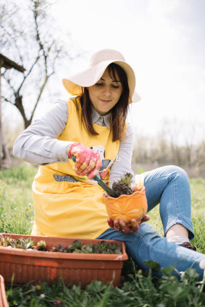 istock Girl putting plant into pot using hand shovel 1223245088