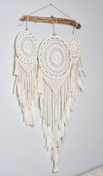 istock Three beautiful white dream catcher on the light color wall. Boho handmade style decor. 1223245341