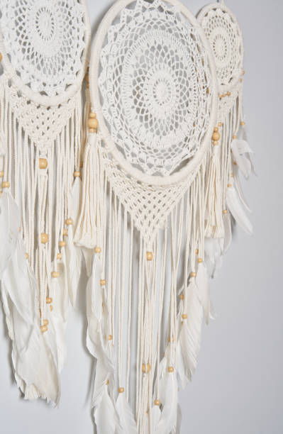 istock Three beautiful white dream catcher on the light color wall. Boho handmade style decor. 1223245557