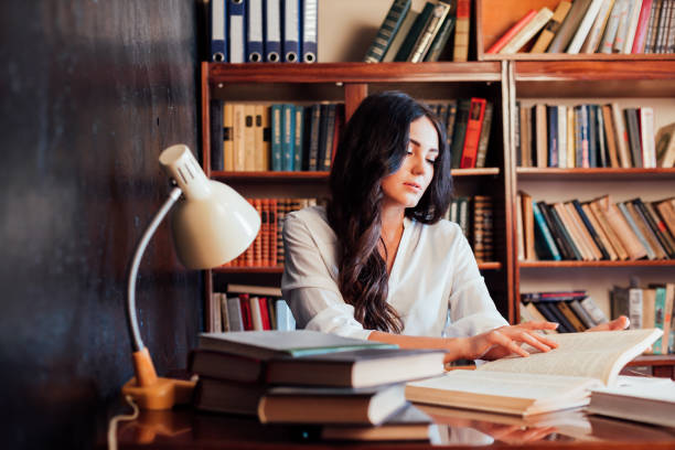 istock girl is preparing for the exam reading book at the library 1223245805