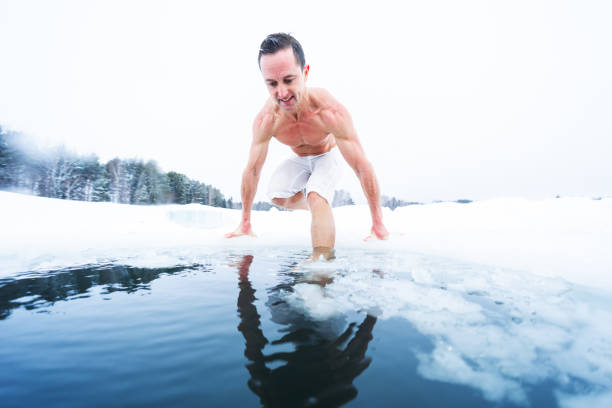 istock Young athletic man going to have ice bath in the winter pond 1223245878