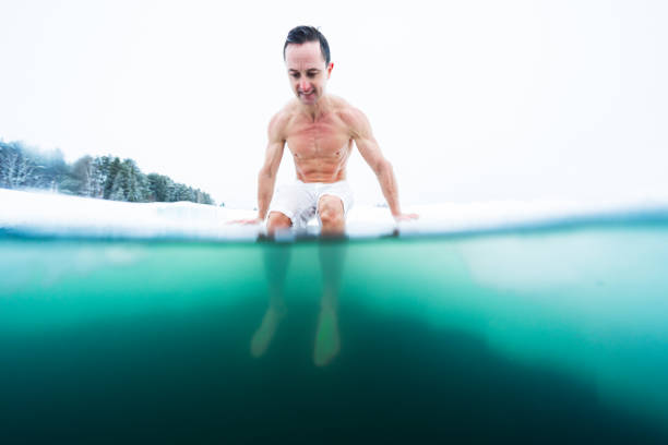 istock Young athletic man going to have ice bath in the winter lake 1223246987
