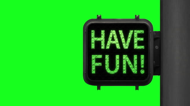 Live Life. Have Fun!—Chroma Key shot of Green Walk Signal with hopeful phrase with green screen in the background