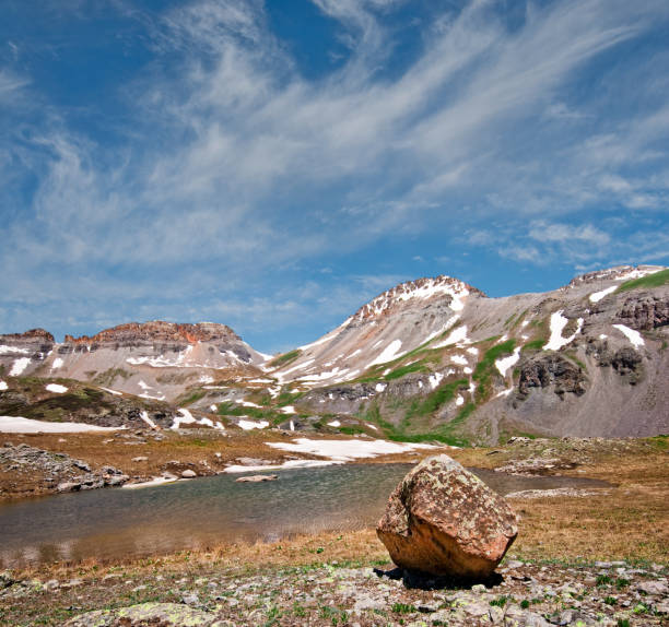 Glacial Erratic in Upper Ice Lakes Basin Large boulders known as glacial erratics, are evidence of past ice ages. These boulders are deposited by the constant downhill movement of the glacier and left exposed as the glacier recedes. This glacial erratic was found at Upper Ice Lake in the San Juan mountains of southern Colorado.  The San Juans are a high altitude range of mountains that straddle the Continental Divide.  This wide-open landscape, at 12,300, is well above timberline.  This photograph was taken from Upper Ice Lake in the San Juan National Forest near Silverton, Colorado, USA. jeff goulden san juan mountains stock pictures, royalty-free photos & images