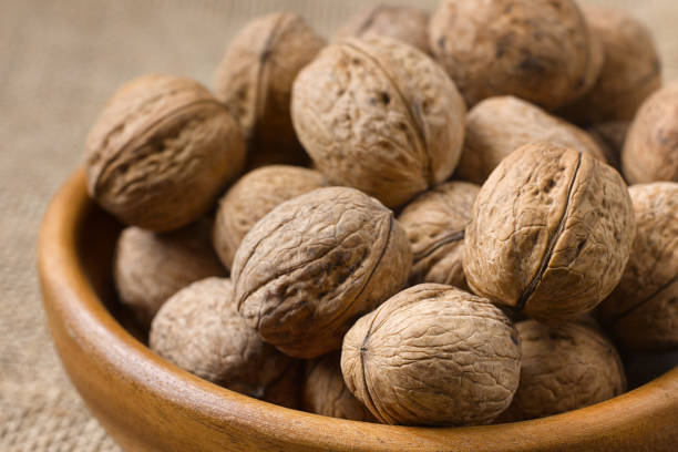 istock nuts in a wooden plate 1223253203