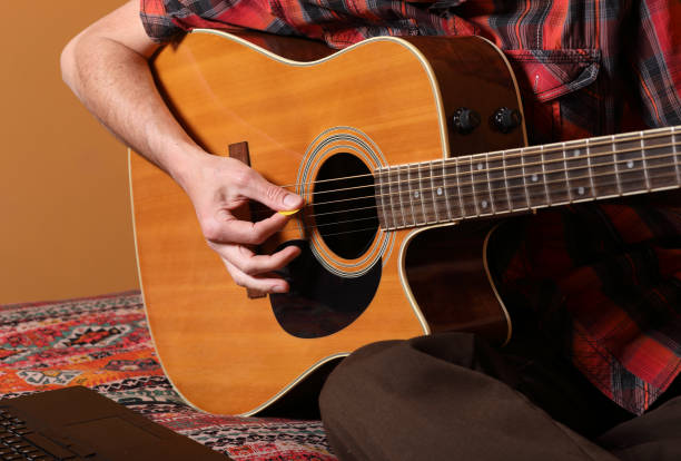 istock COVID-19 Doing Things at Home Man Learns Guitar Pick MS 1223253667