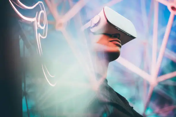 Pretty young African girl adjusting the VR headset on the modern background.