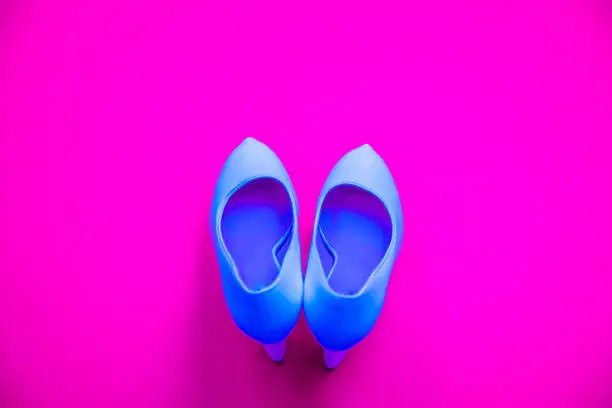 Blue high heeled shoes on pink purple background - top view concept - blank empty room space for text or copy. Classic dress up fashion. Heels pointing up. Dressed up.