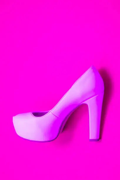 Pink high heeled shoes on pink purple background - top view concept - blank empty room space for text or copy. Suitable for holidays like Valentine's. Classic dress up fashion. Profile of heel