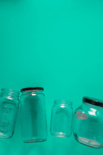 istock Isolated glass jars, flat on teal mint green background, blank empty room space room for text, copy, or copy space on top. Recycling program or campaign image with an assortment of top view containers 1223258864