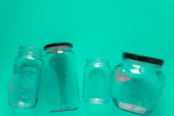 istock Isolated glass jars laid flat and center on teal mint green background. Recycling program or campaign image with an assortment of top view containers. Conceptual awareness for reusable recyclables. 1223258868