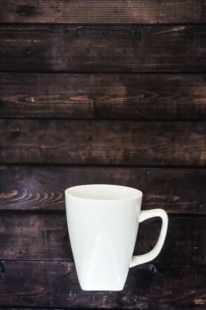 One single coffee mug on wooden table background - 1 java espresso for morning pick me up coffee break with blank empty room for text or copy space. Rustic coffee house look with tasty caffeine.