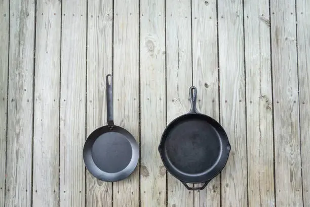 Carbon steel vs cast iron versus teflon pans and skillets - blank empty room for text or copy space on top. Cookware battle comparison comparing healthier kitchen cooking options. Stove to oven.