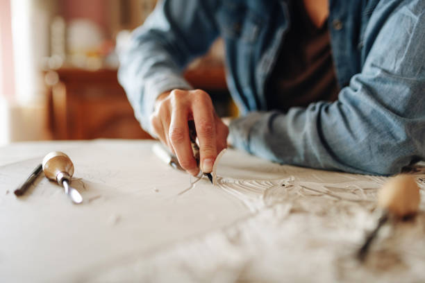 Close up of unrecognizable woman doing linocut technique with copy space