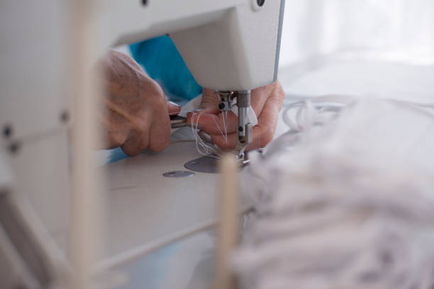 istock Cutting thread from the attached rubber band to the fabric. Face masks production. 1223266964