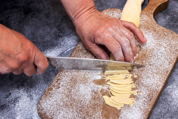 istock Man preparing bread dough on wooden table in a bakery close up 1223267719
