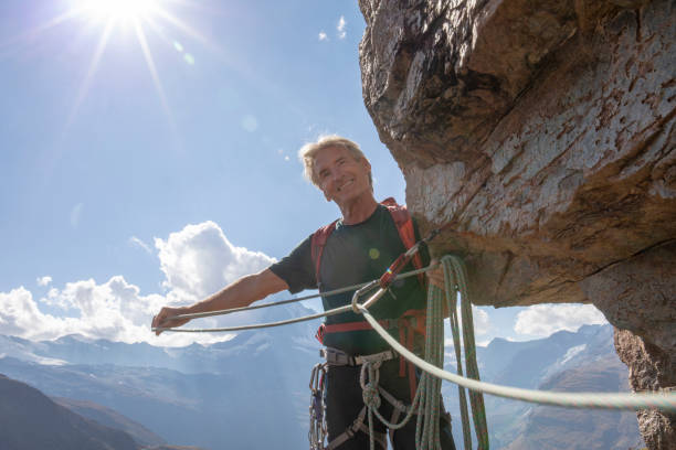 istock Rock climber smiles as he pulls the climbing rope through carabiner 1223269442