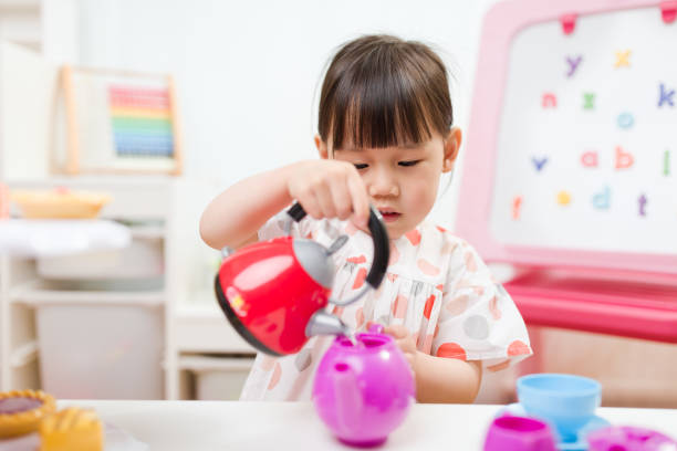 niña niña fingir juego preparando la fiesta de té en casa - tea party little girls teapot child fotografías e imágenes de stock