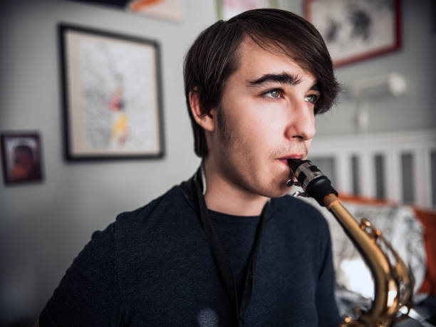 istock Teenager playing sax in his room 1223278020