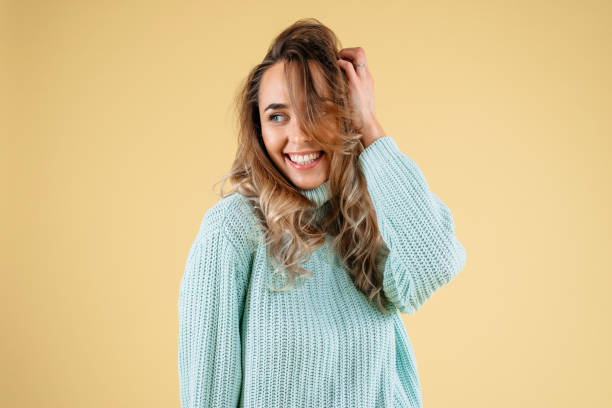 istock Beautiful standing woman model posing and smiling solated on a yellow background 1223281380