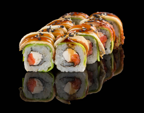 istock Sushi roll with salmon, cheese, avocado, eel, unagi sauce and sesame isolated on black background with reflection 1223282091