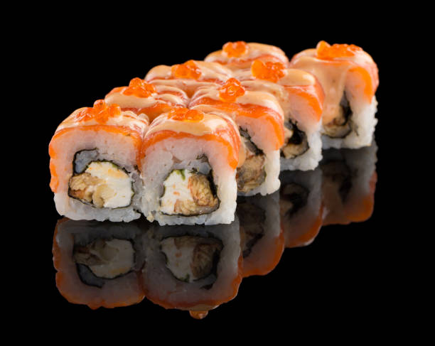 istock Sushi roll with salmon, cheese, eel, sauce and caviar isolated on black background with reflection 1223282291