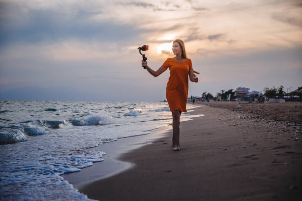 istock Woman vlogging from the seaside at sunset 1223283798