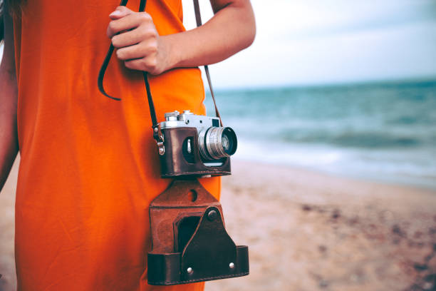 istock Woman with retro camera on the beach 1223284013