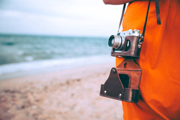 istock Woman with retro camera on the beach 1223284066