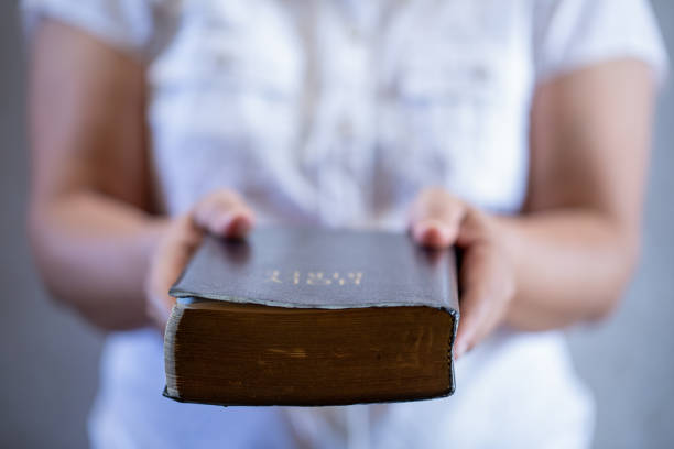 Sharing the Gospel with the youth Sharing the Gospel with the youth. Handing a bible to a person who is interested in becoming a christian. gospel stock pictures, royalty-free photos & images
