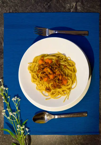 Vegan Wholegrain Spaghetti Bolognese on plates with colorful background