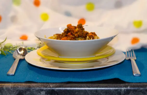 Vegan Wholegrain Spaghetti Bolognese on plates with colorful background