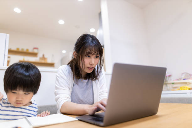 istock Young mother working at home, son is sitting next to her 1223289854