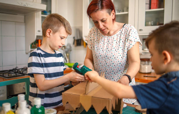 istock Mom and kids making a cardboard dinosaur costume 1223289865
