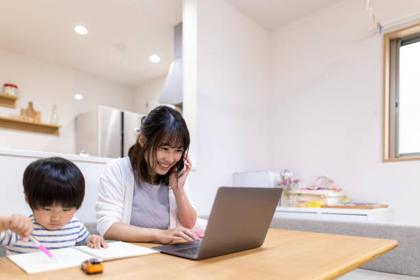 istock Young mother working at home, son is sitting next to her 1223289869